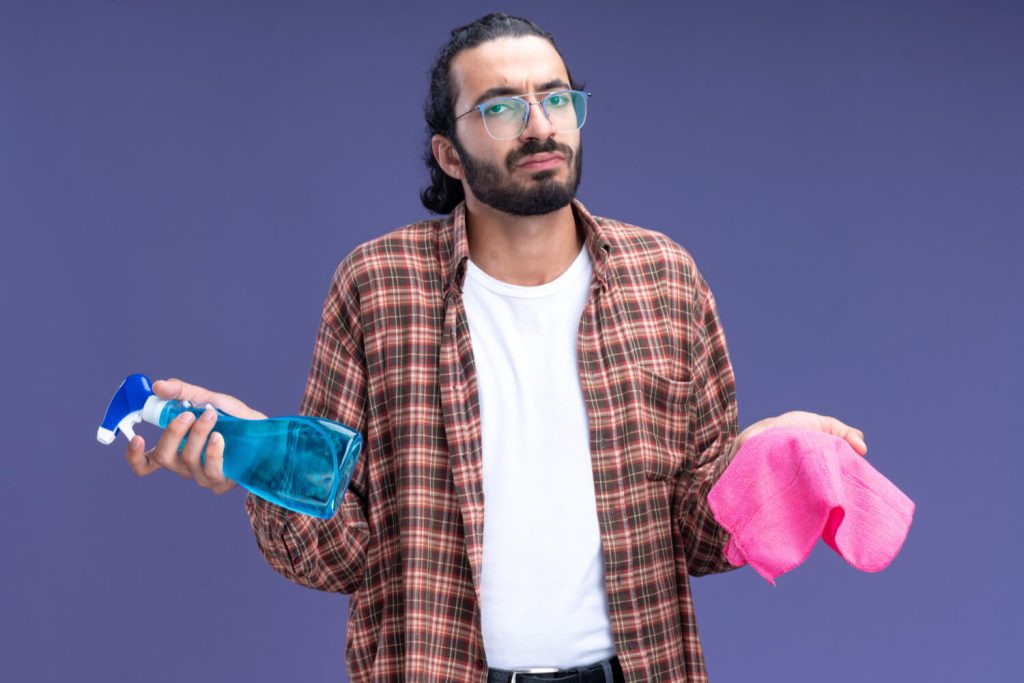 person holding a cleaning spray and sponge